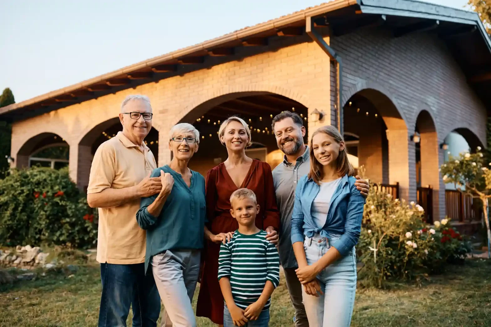 Família feliz reunida na varanda de uma casa aconchegante ao pôr do sol, celebrando momentos especiais com risos e amor em um ambiente ao ar livre. Post: O que é uma holding familiar.