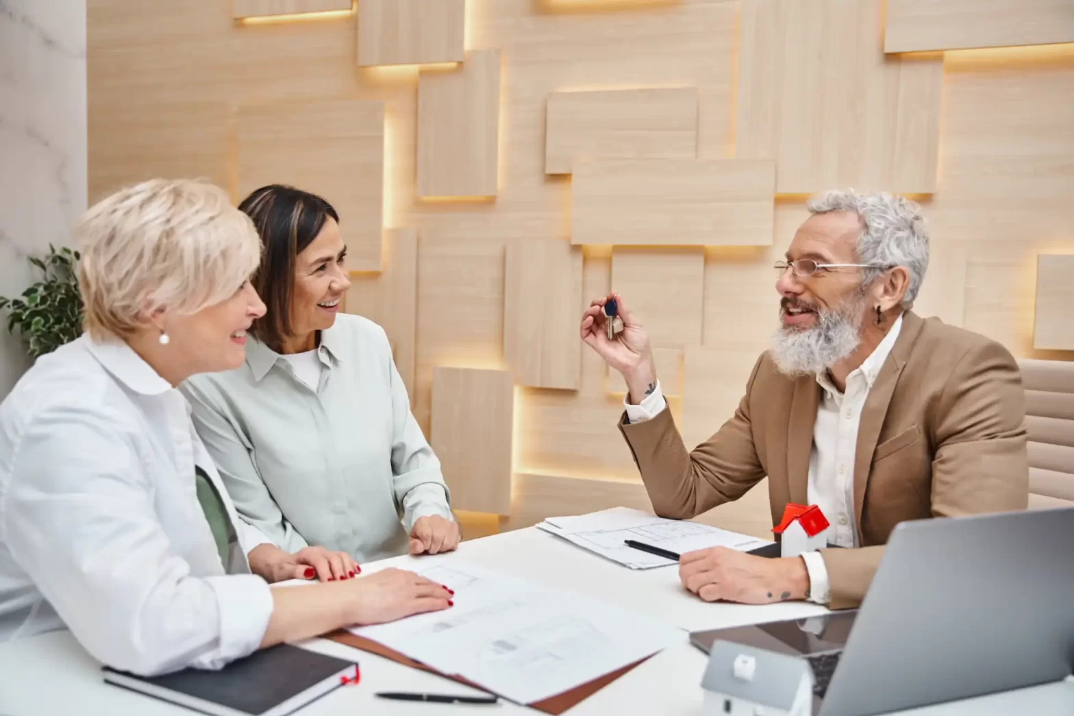 Homem apresentando produto ou ideia para duas mulheres em uma reunião de negócios, com ambiente profissional e moderno ao fundo. ADI 2446