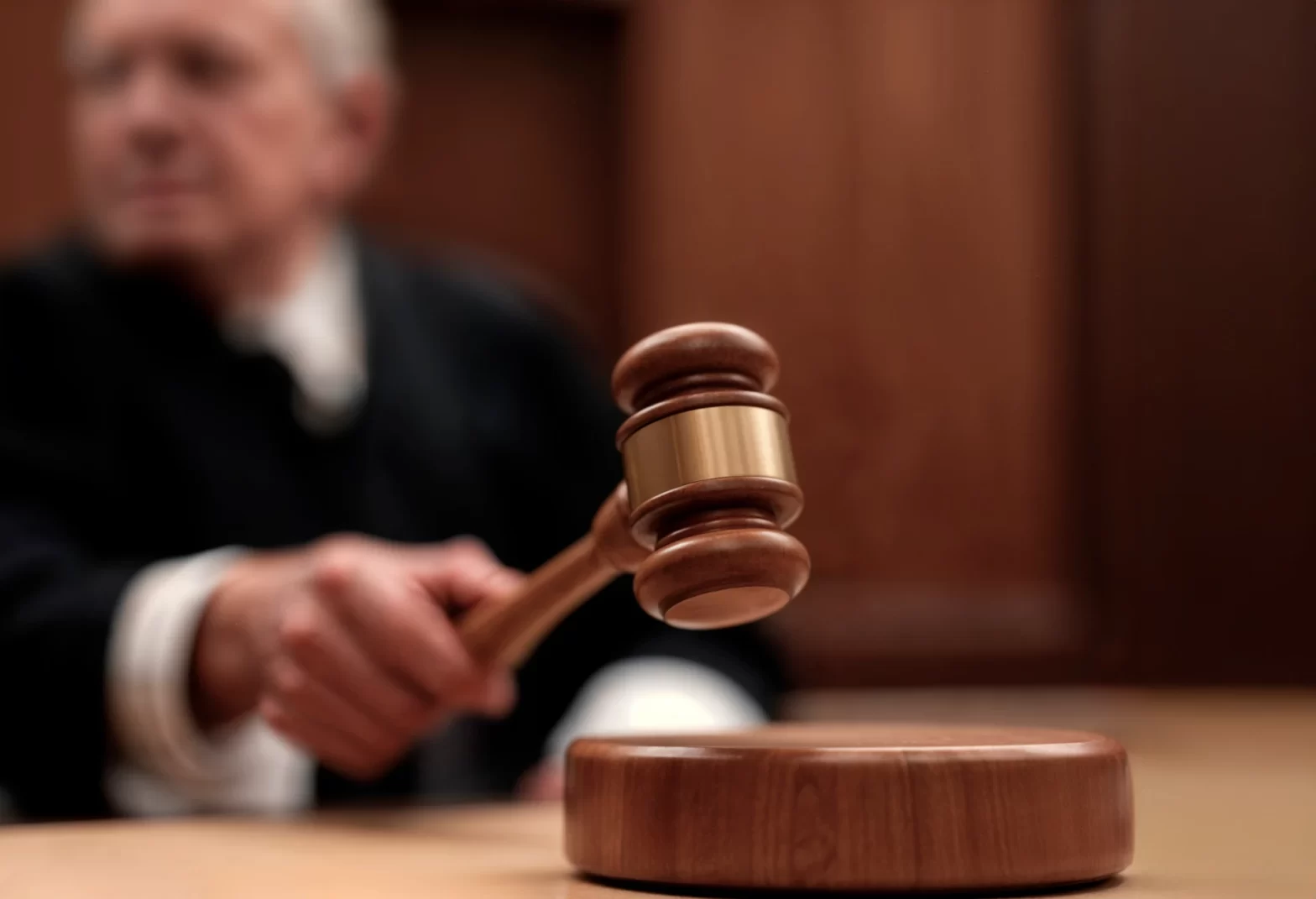 Decisões recentes sobre aposentadoria especial de motoristas e caminhoneiros. Juiz usando martelo de madeira em julgamento de tribunal, simbolizando decisão judicial e autoridade na sala de audiência.